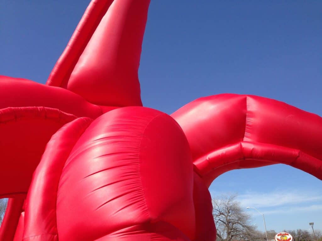 The Eagle has Landed, HOMECOMING! Committee, 2014: close-up of the giant red inflatable eagle’s curving legs against a blue sky